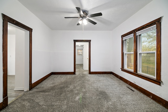 carpeted empty room with a textured ceiling and ceiling fan