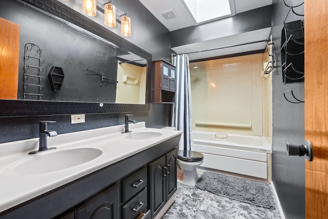 full bathroom featuring tasteful backsplash, vanity, toilet, a skylight, and shower / bath combo with shower curtain