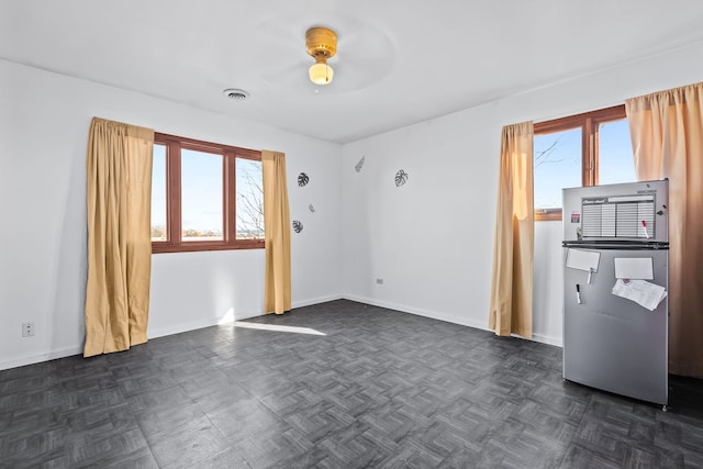 unfurnished room with dark parquet floors and ceiling fan