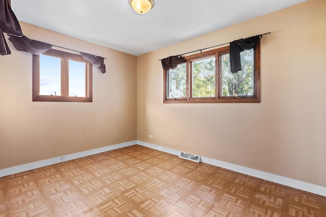 empty room featuring light parquet flooring and a wealth of natural light