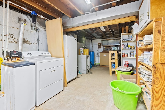 basement featuring washing machine and dryer and white refrigerator