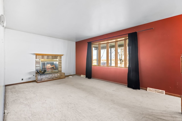 unfurnished living room with light carpet and a fireplace