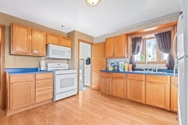 kitchen featuring white appliances, sink, and light wood-type flooring