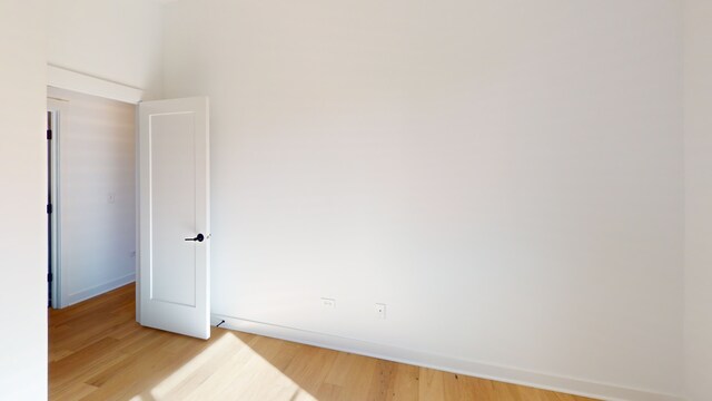 unfurnished room with hardwood / wood-style flooring