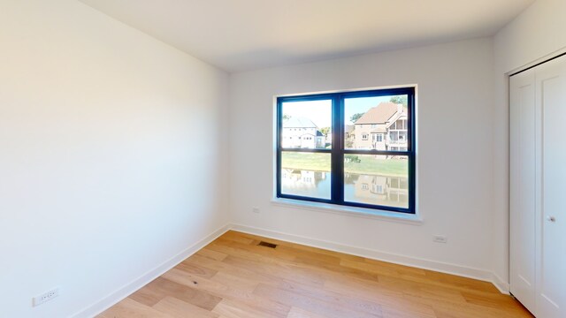 unfurnished bedroom featuring a closet and light hardwood / wood-style flooring