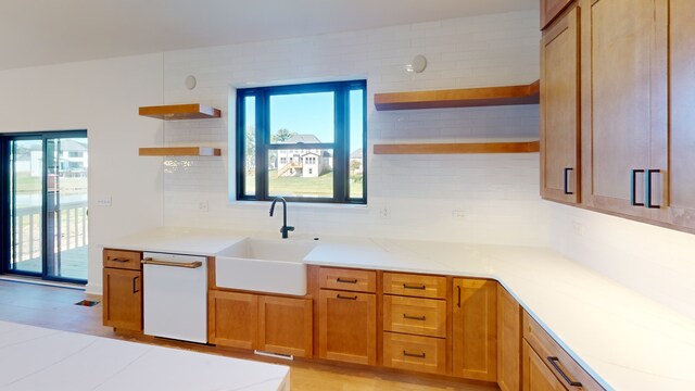 kitchen featuring dishwasher, decorative backsplash, and sink