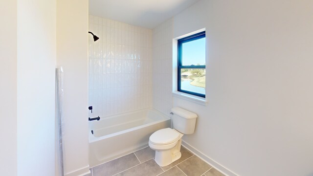 bathroom with toilet, tiled shower / bath, and tile patterned floors