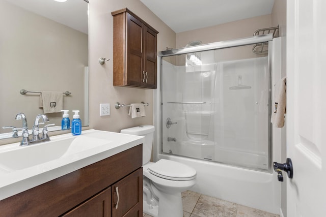 full bathroom with tile patterned flooring, vanity, bath / shower combo with glass door, and toilet