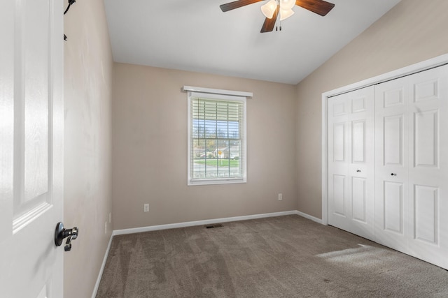 unfurnished bedroom with carpet flooring, a closet, ceiling fan, and lofted ceiling