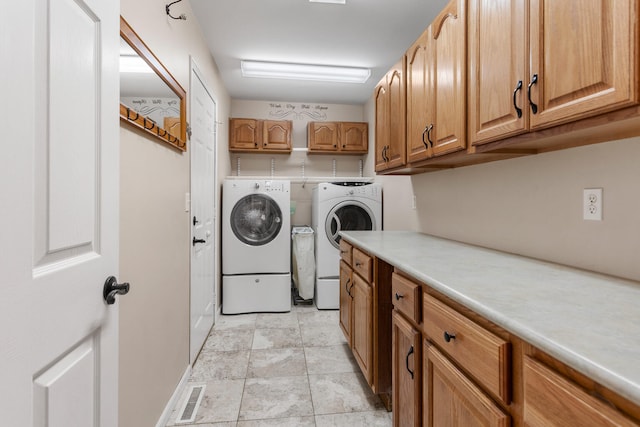 laundry room with washer and clothes dryer and cabinets