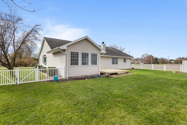 back of property with a lawn and a deck