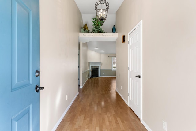 hallway featuring a notable chandelier and light hardwood / wood-style floors