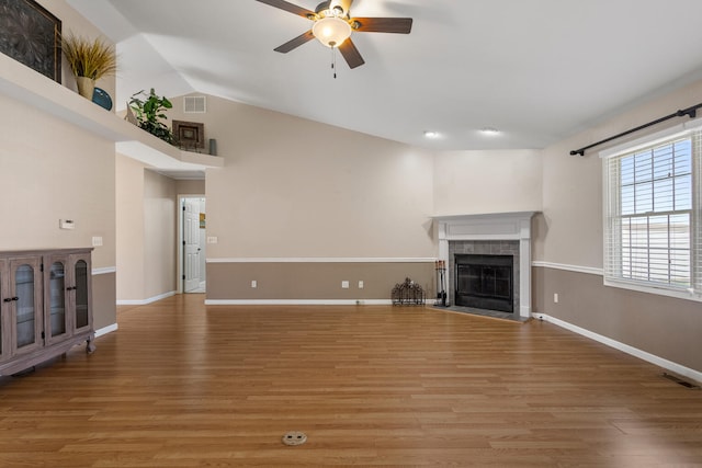 unfurnished living room with lofted ceiling, ceiling fan, wood-type flooring, and a fireplace