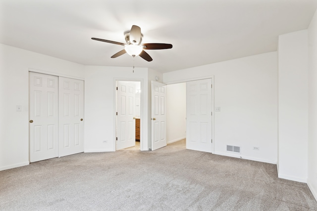 unfurnished bedroom with light colored carpet and ceiling fan