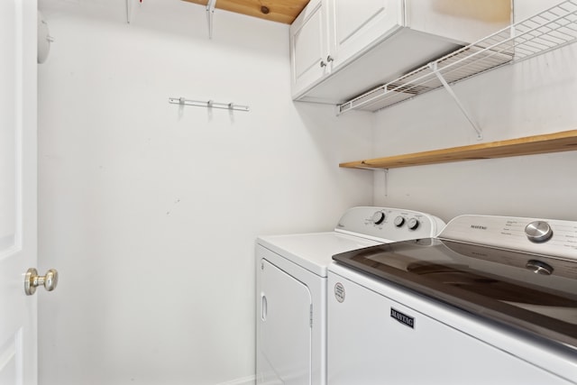 laundry area with washer and clothes dryer and cabinets