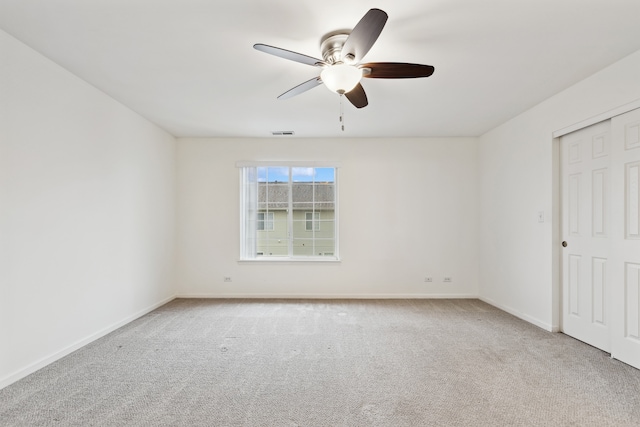 empty room with ceiling fan and light carpet