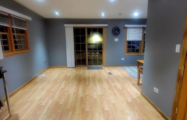 unfurnished dining area with wood finished floors, visible vents, and baseboards