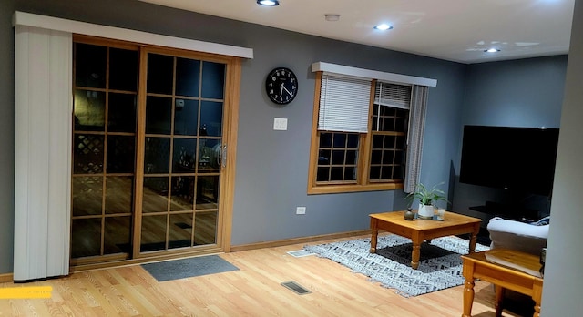 living area featuring baseboards, visible vents, wood finished floors, and recessed lighting