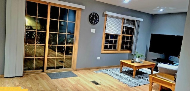 living room featuring visible vents, baseboards, and wood finished floors