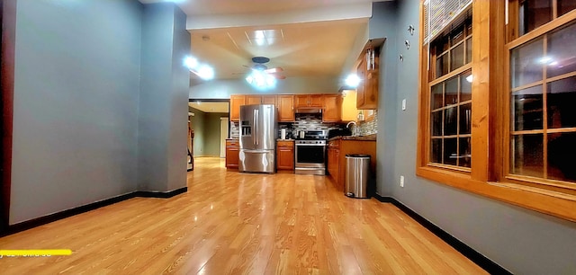 kitchen with ceiling fan, sink, stainless steel appliances, tasteful backsplash, and light wood-type flooring