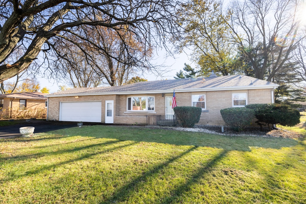 ranch-style home with a garage and a front yard