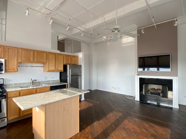 kitchen featuring a kitchen bar, sink, dark hardwood / wood-style floors, a kitchen island, and appliances with stainless steel finishes