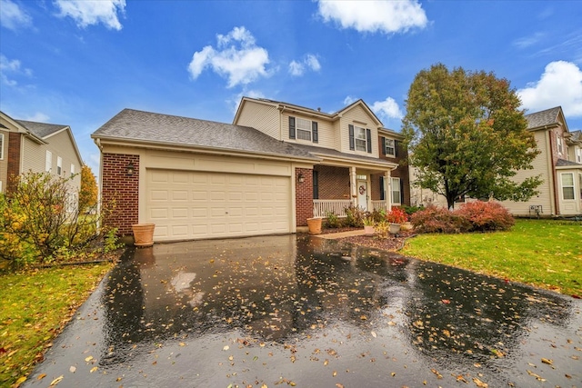 view of front of home with a garage, a front yard, and a porch