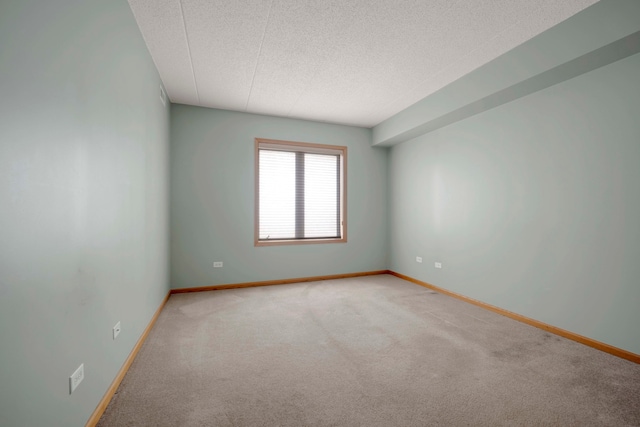 spare room featuring a textured ceiling and light colored carpet