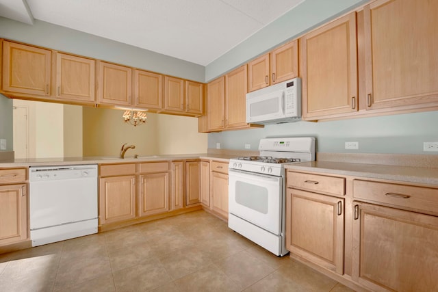 kitchen with light brown cabinets, white appliances, sink, and a notable chandelier