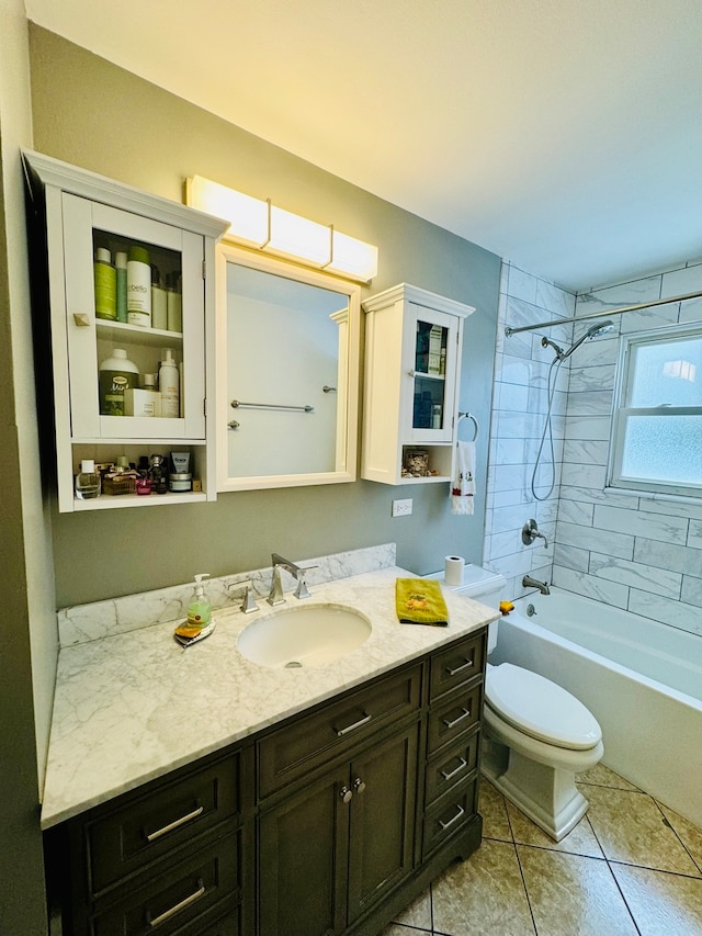 full bathroom with vanity, tile patterned flooring, tiled shower / bath, and toilet