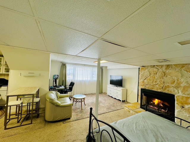 living room with a paneled ceiling, light carpet, and a fireplace