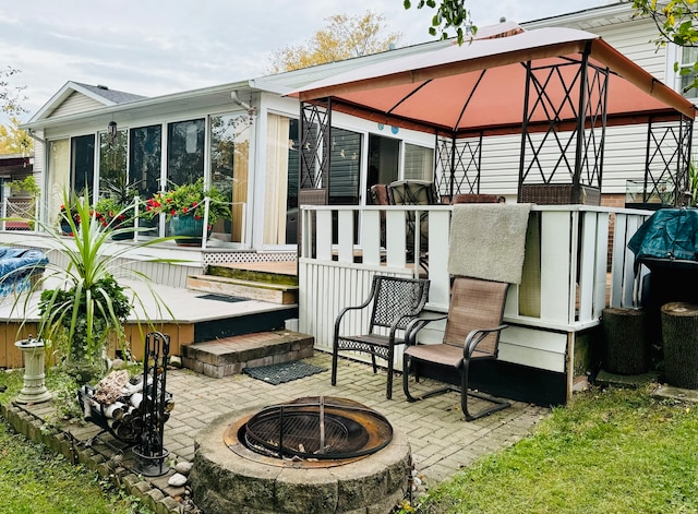 rear view of house with a patio, a fire pit, a gazebo, and a deck