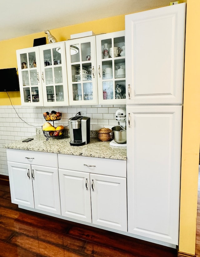 bar featuring white cabinetry, dark hardwood / wood-style flooring, tasteful backsplash, and light stone counters