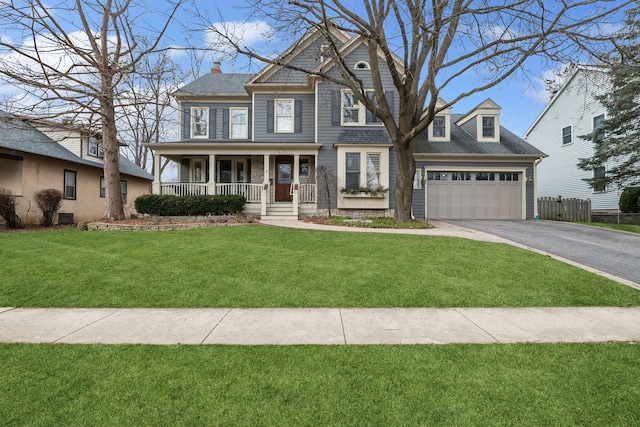 view of front of house featuring a garage, a front yard, and a porch