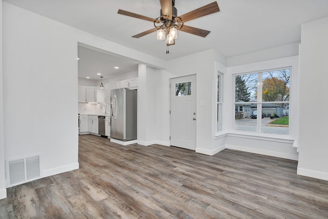 unfurnished living room with ceiling fan and light hardwood / wood-style flooring