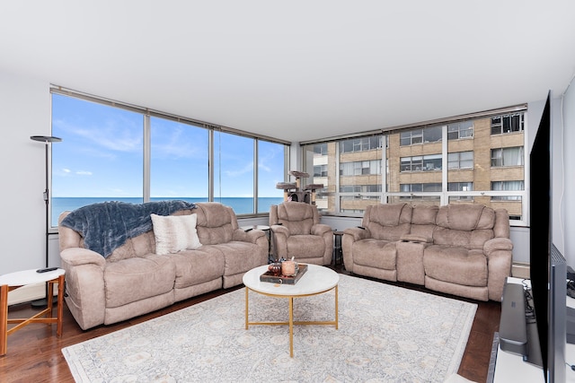 living room featuring floor to ceiling windows, a water view, and dark hardwood / wood-style floors