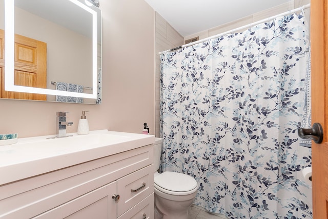 bathroom with a shower with curtain, vanity, toilet, and tile patterned floors