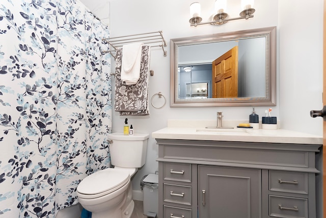 bathroom featuring curtained shower, vanity, and toilet