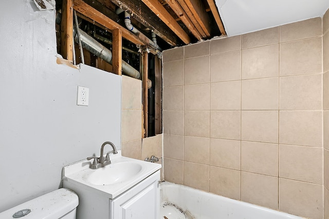 bathroom with a bathing tub, vanity, and toilet