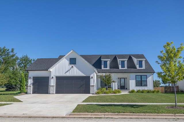 modern inspired farmhouse with a garage and a front lawn