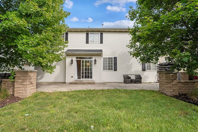 rear view of property featuring a lawn and a patio