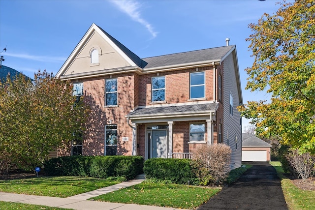 view of front of house featuring an outbuilding, a garage, and a front lawn