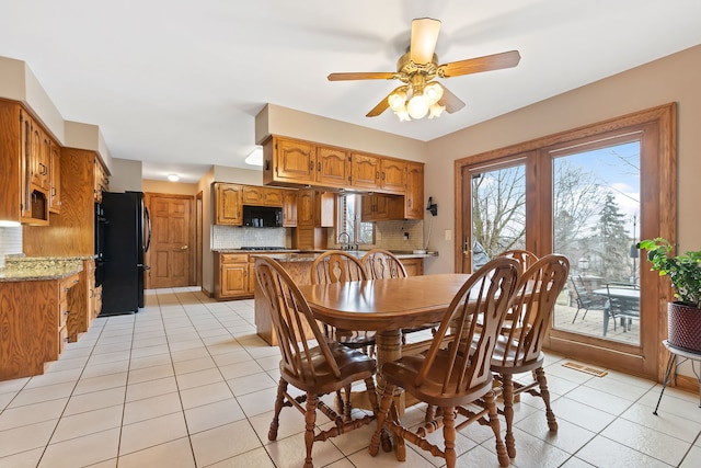 dining space with light tile patterned flooring, ceiling fan, and sink