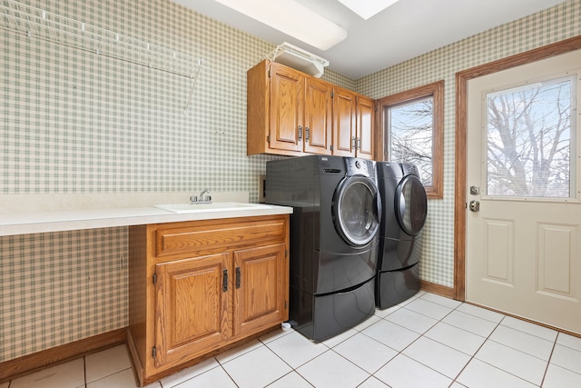 laundry area featuring cabinets, sink, washer and dryer, and light tile patterned floors