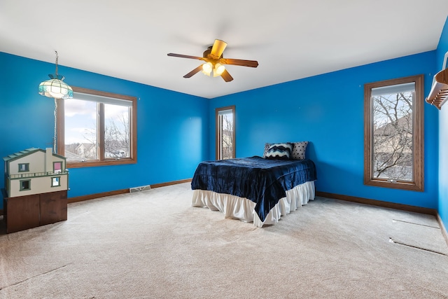 bedroom featuring multiple windows, carpet flooring, and ceiling fan