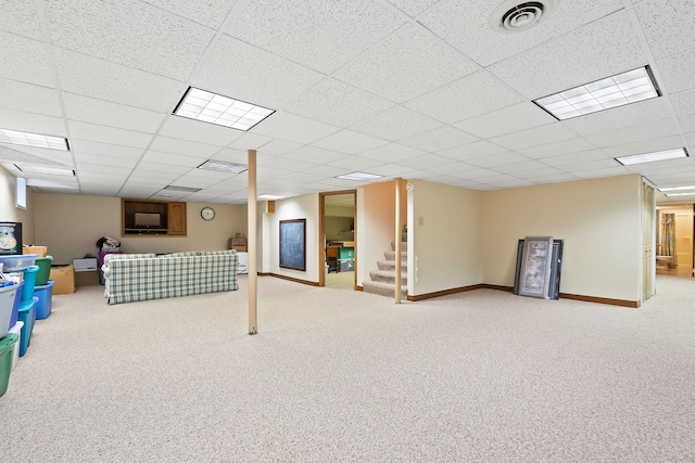 basement with a paneled ceiling and carpet