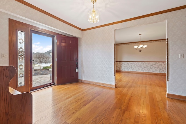 entryway featuring a notable chandelier, crown molding, and light hardwood / wood-style flooring