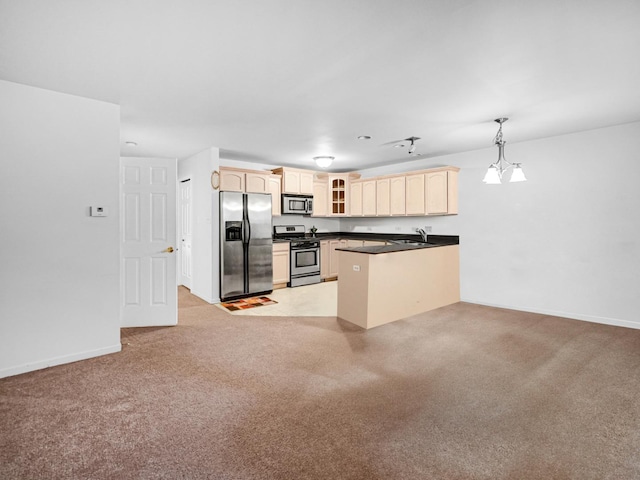 kitchen featuring pendant lighting, light carpet, sink, kitchen peninsula, and stainless steel appliances