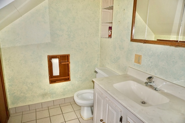 bathroom with toilet, vanity, and tile patterned floors