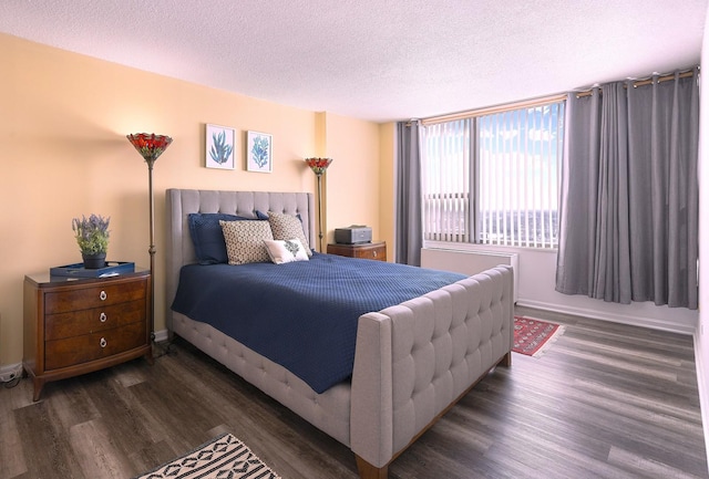 bedroom featuring a textured ceiling, wood finished floors, and baseboards